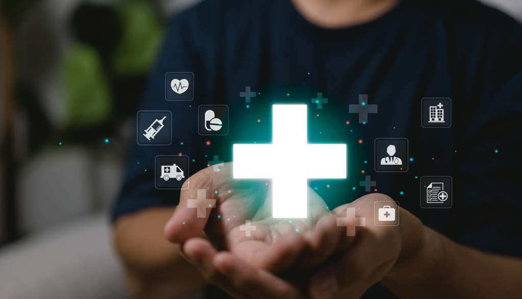 Hands holding a green glowing medical cross