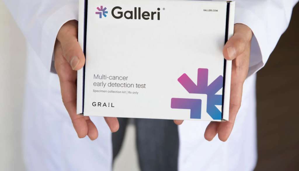 Hands holding a Galleri multi-cancer detection test box.