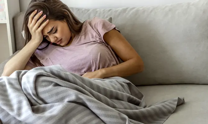 Young woman with stomach pain in need of urgent care in St. Louis, MO