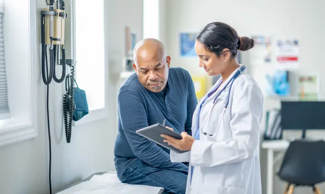 Doctor reviewing test results with middle aged male patient