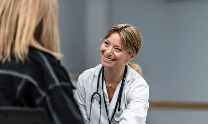 Concierge doctor smiling warmly at a patient.