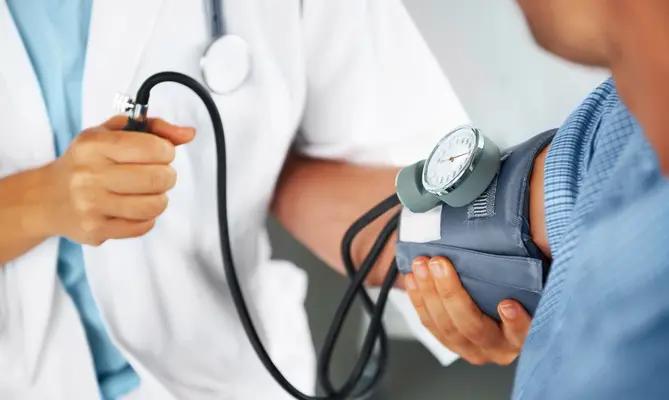 Doctor measuring patient's blood pressure.