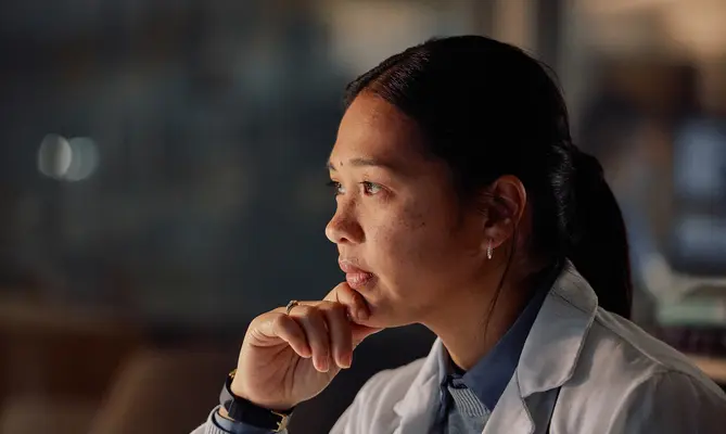 Pensive concierge physician reviewing data on a computer screen