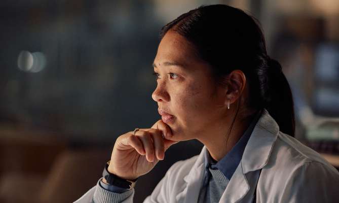 Pensive concierge physician reviewing data on a computer screen