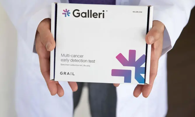 Hands holding a Galleri multi-cancer detection test box.