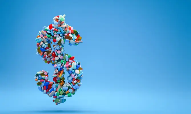 Dollar sign made of colorful pills on a blue background.