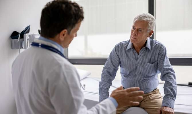 Doctor consulting with patient in a bright, modern clinic room.