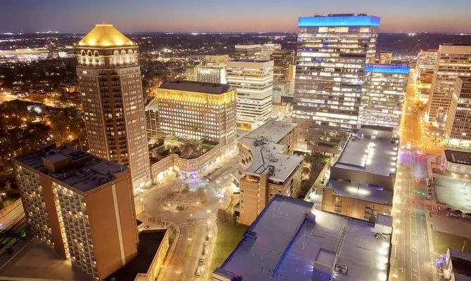 Clayton, Missouri, skyline at dusk with tall buildings and vibrant lights.