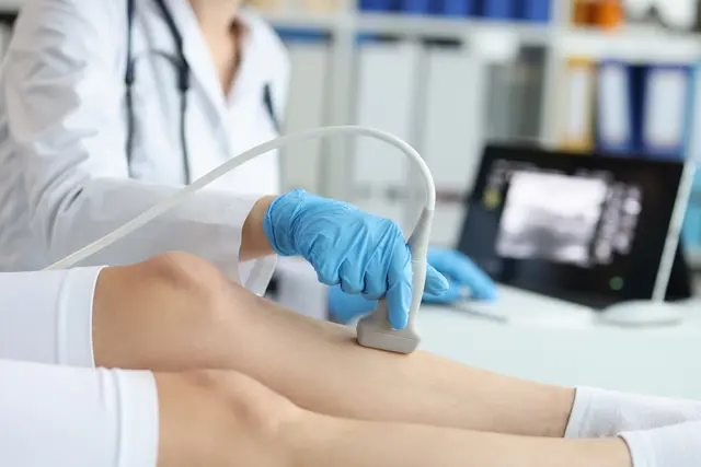 Physician uses an ultrasound machine on a patient.