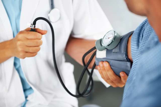 Doctor measuring patient's blood pressure.