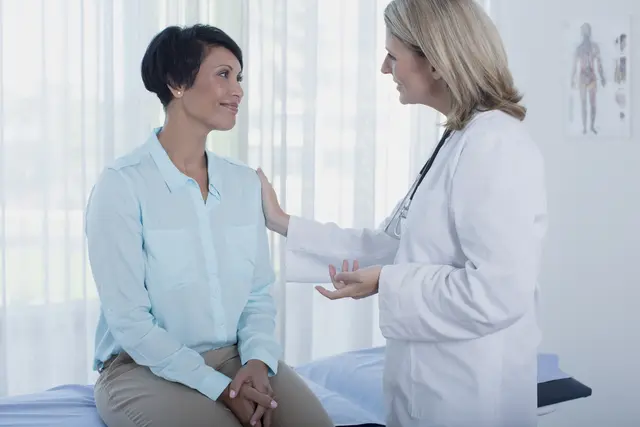 A patient in discussion with a doctor in a bright examination room