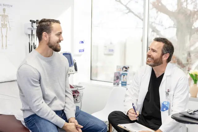 A doctor and his patient talking and smiling at each other