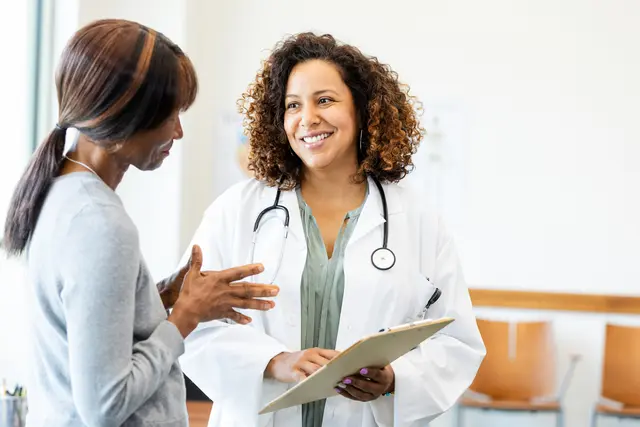 A smiling doctor speaking to her patient