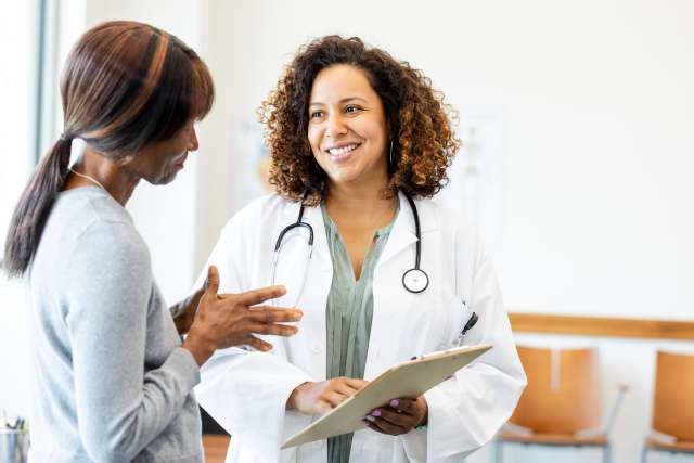 A smiling doctor speaking to her patient